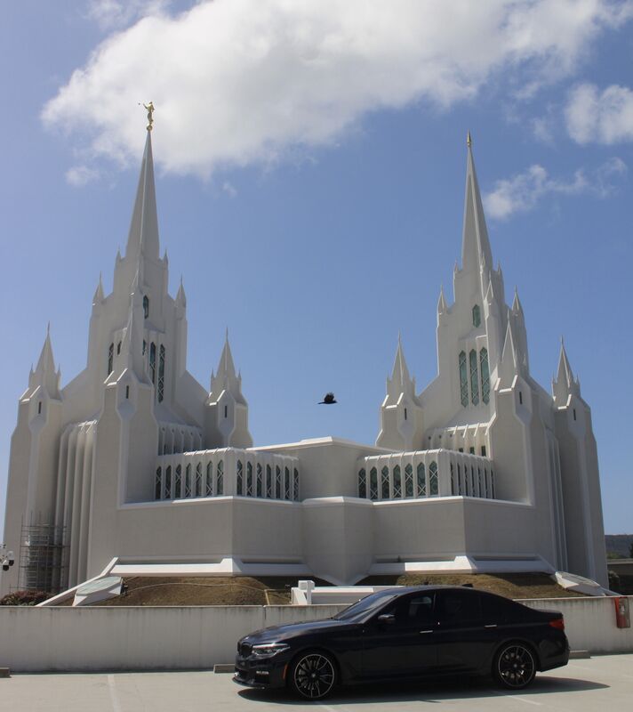 540i parked near a chapel - clean lines and architecture