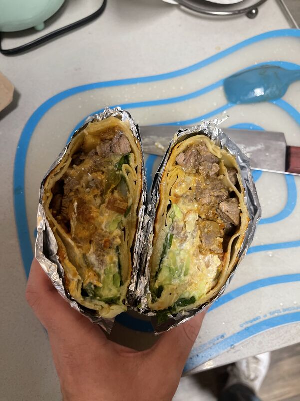Burrito cut in half showing all the fillings inside